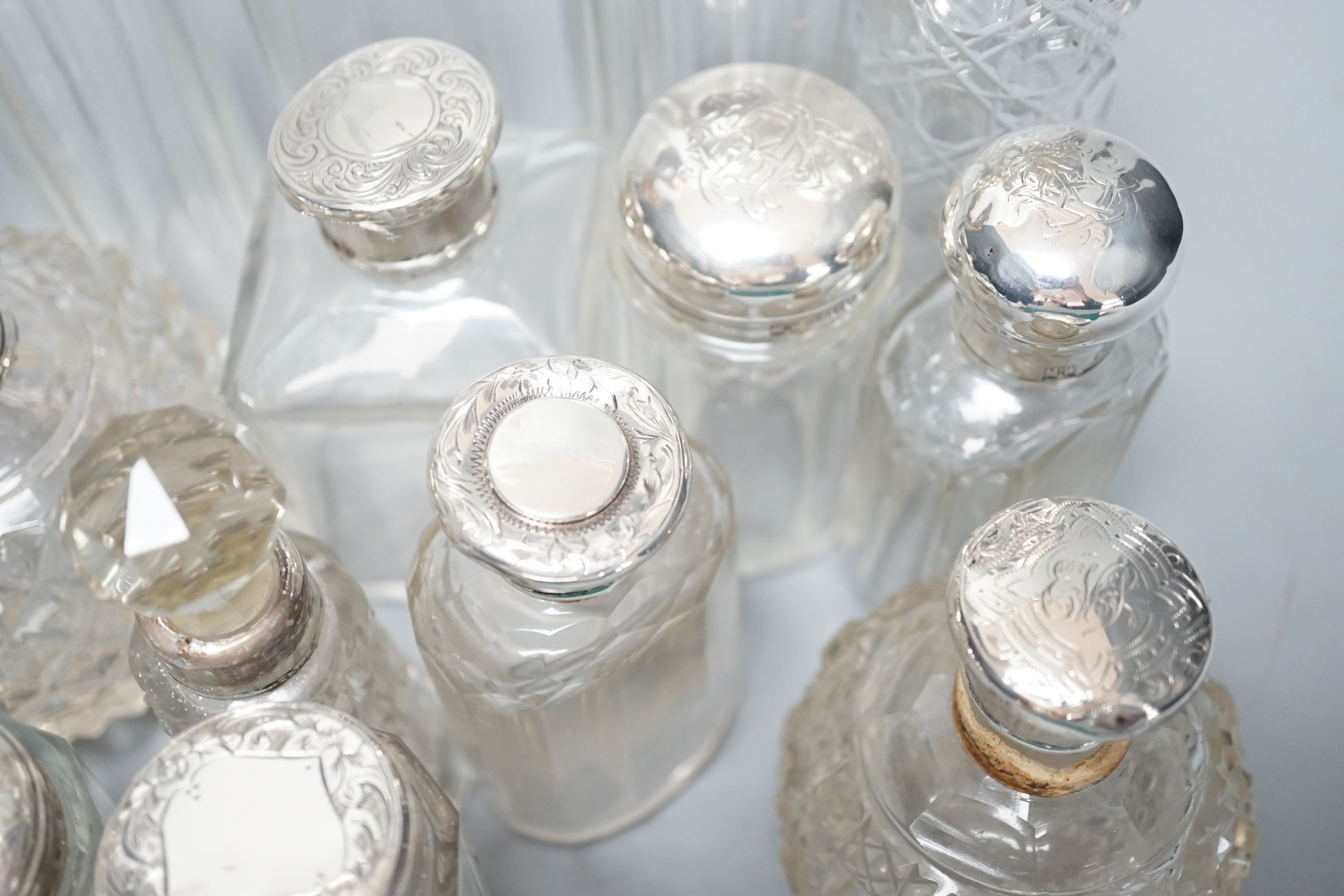 A collection of assorted mainly silver-capped scent bottles and toilet bottles.
